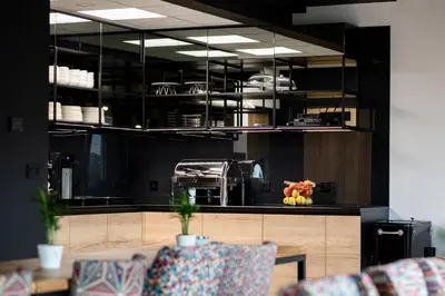 a kitchen with black cabinets and a table and chairs at Jura Hotel Osiek in Olkusz