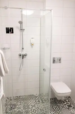 a bathroom with a glass shower with a toilet at Jura Hotel Osiek in Olkusz