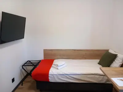 a bedroom with a bed with a tv on the wall at Jura Hotel Osiek in Olkusz