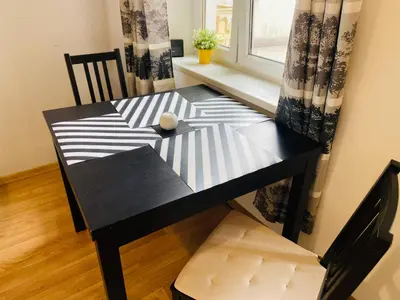 a black dining room table with a chair and a window at Luxodonta Apartment in Kraków