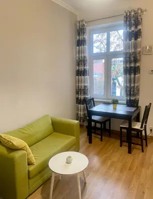 a living room with a green couch and a table at Luxodonta Apartment in Kraków