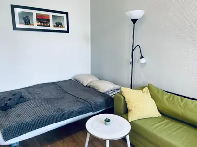 a bedroom with a bed and a couch and a table at Luxodonta Apartment in Kraków