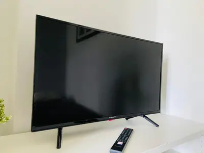 a flat screen tv sitting on a table with a remote control at Luxodonta Apartment in Kraków