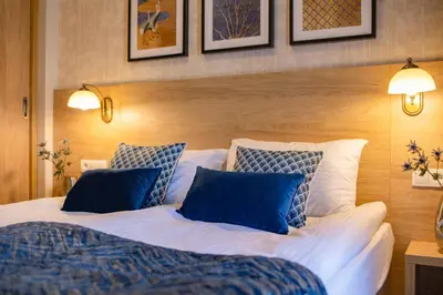 a bedroom with a large bed with blue pillows at Portal House Apartments in Kraków