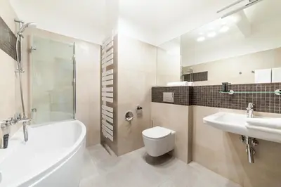 a bathroom with a tub and a toilet and a sink at Portal House Apartments in Kraków