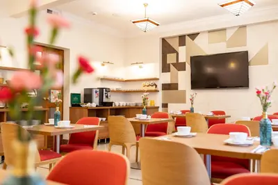 a restaurant with tables and chairs and a flat screen tv at Portal House Apartments in Kraków