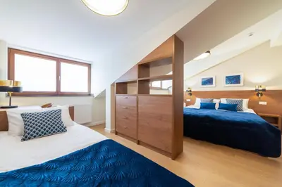 a bedroom with two beds and a large window at Portal House Apartments in Kraków