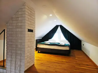 a attic room with two beds and a staircase at Domek z jacuzzi Cztery Pory Roku in Czchów