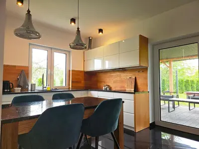 a living room with a chair and a table at Domek z jacuzzi Cztery Pory Roku in Czchów