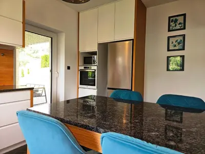 a kitchen with a counter and chairs in it at Domek z jacuzzi Cztery Pory Roku in Czchów