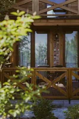 a screened in porch of a house with glass doors at Domki na Górniej Łące - Domek Górny in Łazany