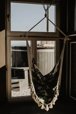a hammock hanging in front of a window at Domki na Górniej Łące - Domek Górny in Łazany