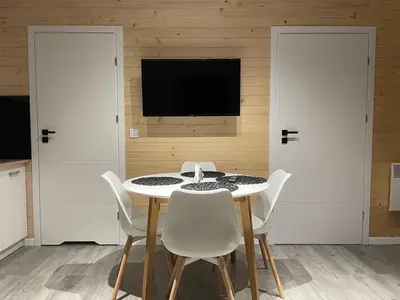 a dining room with a white table and white chairs at RedDoor Zator Lake Houses in Zator