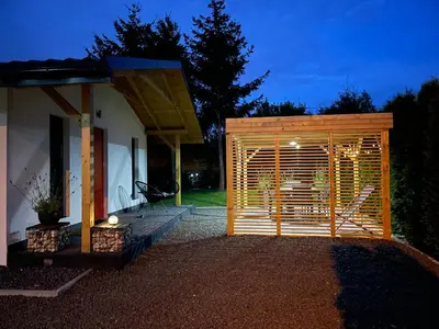 a wooden shed in front of a house at night at RedDoor Zator Lake Houses in Zator