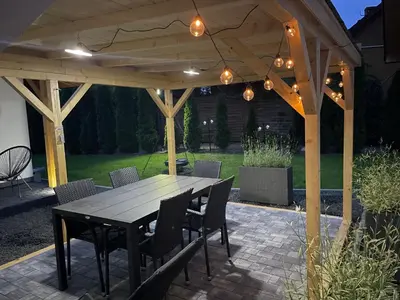 a wooden pergola with a table and chairs at RedDoor Zator Lake Houses in Zator