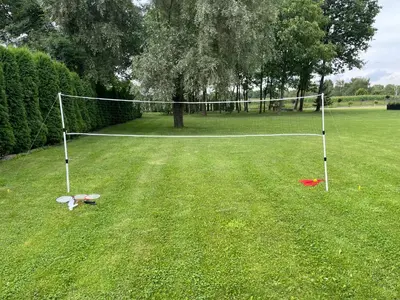 a net in the middle of a grass field at RedDoor Zator Lake Houses in Zator
