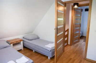 a small room with two beds and a mirror at Domki Łowisko Wieniec in Gdów