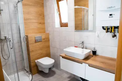 a bathroom with a sink and a toilet and a shower at Domki Łowisko Wieniec in Gdów