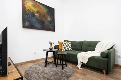 a living room with a green couch and a table at Apartment à côté the train station - by Upstairs in Kraków
