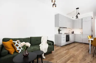 a living room with a green couch and a table at Apartment à côté the train station - by Upstairs in Kraków