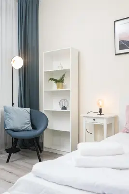 a bedroom with two beds and a blue chair at Apartment à côté the train station - by Upstairs in Kraków