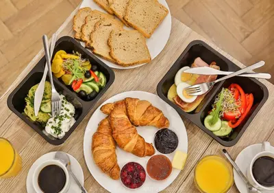 three trays of breakfast food on a table at Apartment à côté the train station - by Upstairs in Kraków