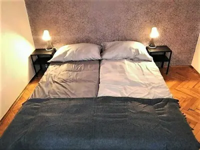 a large bed in a bedroom with two lamps at Floriańska NewTown in Kraków