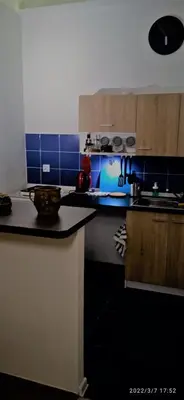 a kitchen with a counter top and a blue tiled wall at Floriańska NewTown in Kraków