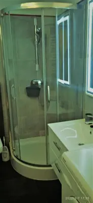 a shower with a glass door next to a sink at Floriańska NewTown in Kraków