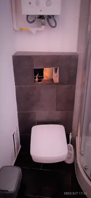a bathroom with a white toilet and a sink at Floriańska NewTown in Kraków