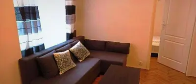 a living room with a brown couch with two pillows at Floriańska NewTown in Kraków