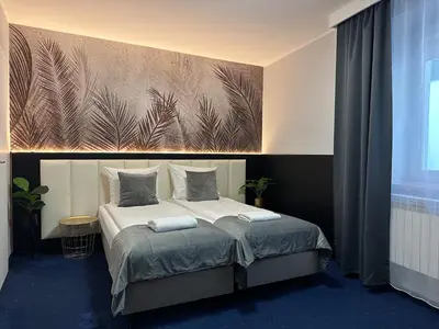 a bedroom with a bed with a painting on the wall at Garbarska 22 Aparthotel in Kraków