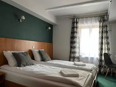 a bedroom with two beds and a window at Garbarska 22 Aparthotel in Kraków