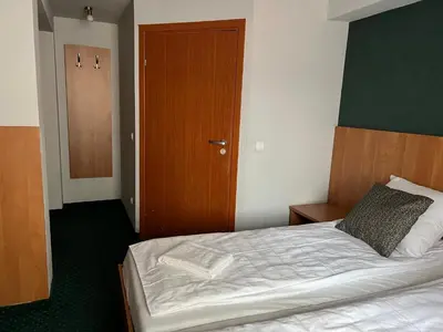 a bedroom with a bed and a wooden door at Garbarska 22 Aparthotel in Kraków