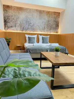 a living room with two beds and a table at Garbarska 22 Aparthotel in Kraków