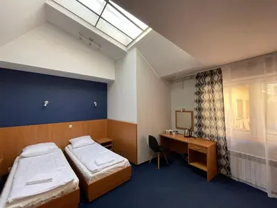 a room with two beds and a desk and a window at Garbarska 22 Aparthotel in Kraków