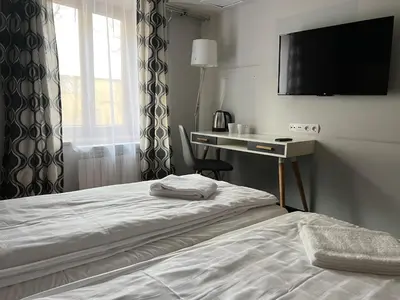 a hotel room with a bed and a desk and a television at Garbarska 22 Aparthotel in Kraków