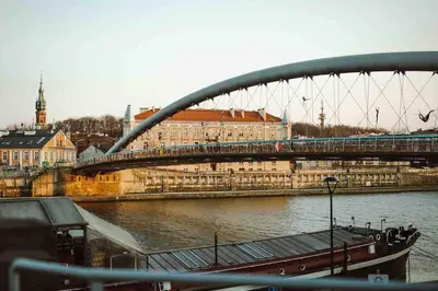 a bridge over a river with a train on it at HAPPY MOMENTS APARTMENTS in Kraków