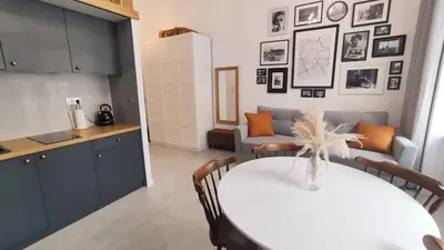 a kitchen and a living room with a table and a couch at Starowislna 43 by Homeprime in Kraków