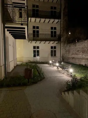 a group of benches in front of a building at night at Luxury Panda Apartment in Old Town in Kraków