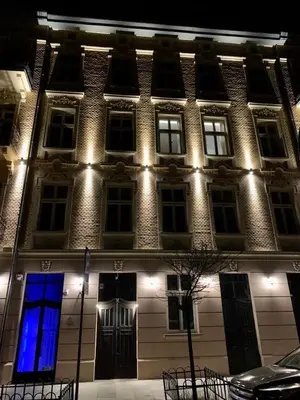 a building with a blue light on the front of it at Luxury Panda Apartment in Old Town in Kraków