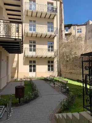 a building with two benches in front of it at Luxury Panda Apartment in Old Town in Kraków
