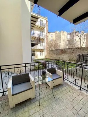a balcony with two chairs and a glass table at Luxury Panda Apartment in Old Town in Kraków
