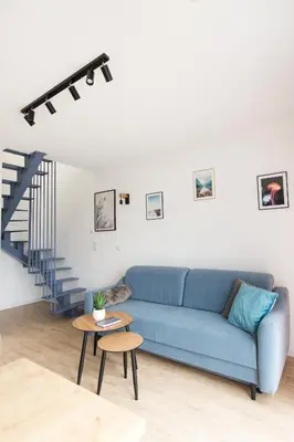 a living room with a blue couch and a table at Słoneczne Zacisze Las obok Zatora in Las