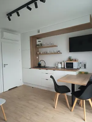 a kitchen with a table and chairs and a microwave at Słoneczne Zacisze Las obok Zatora in Las