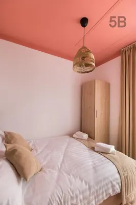a bedroom with a white bed with a pink ceiling at Słoneczne Zacisze Las obok Zatora in Las