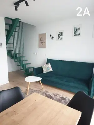 a living room with a green couch and a table at Słoneczne Zacisze Las obok Zatora in Las