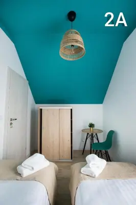 a room with two beds and a blue ceiling at Słoneczne Zacisze Las obok Zatora in Las