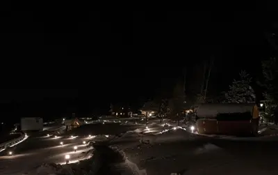 a snowy street at night with street lights at Domek Hobbita z jaskinią SPA - Osada Jaworzyny in Tokarnia