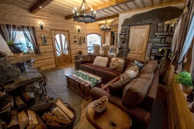 a living room with a couch and a fireplace at Baśniowy Domek Kolędówka z jaskinią SPA - Osada Jaworzyny in Tokarnia
